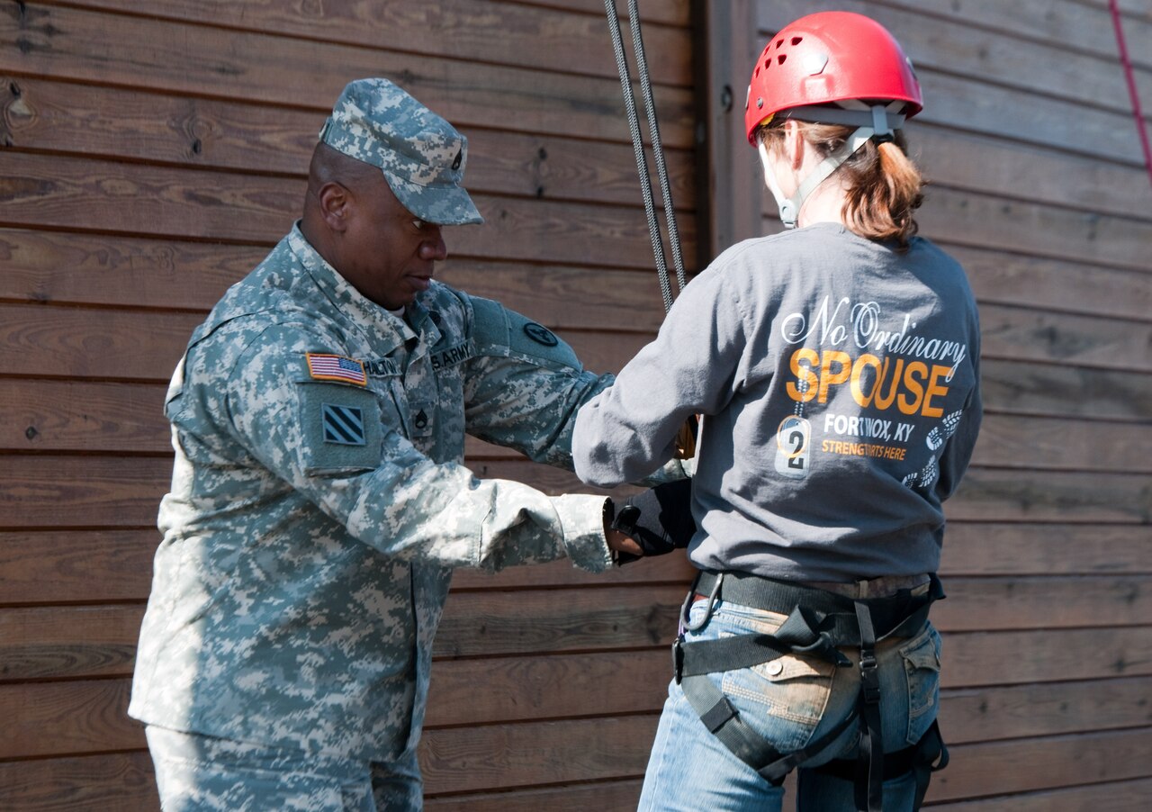A man in a military uniform handles the cables attached to a woman who is in civilian clothing.