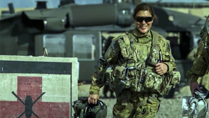 Image of an Airmen holding a helmet and walking.