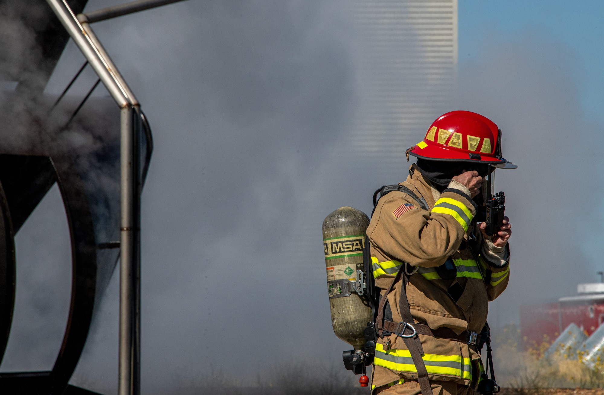 U.S. Air Force Tech. Sgt. Wyatt Matthews, firefighter in the 419th Civil Engineer Squadron, reaches out to fellow firefighters during a readiness training exercise