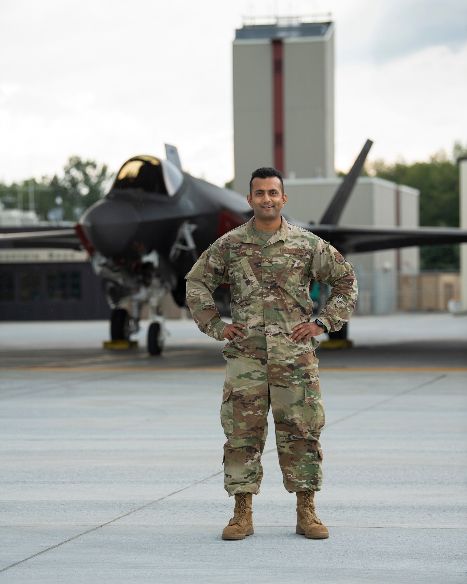 Picture of Airmen 1st Class Komalpreet Saini standing for a picture in front of an F-35A Lightning II aircraft assigned to the Vermont Air National Guard.