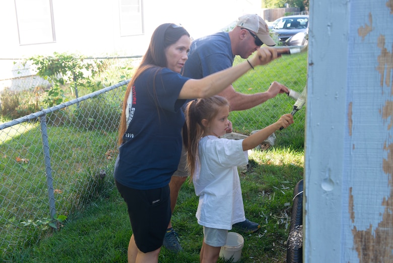 The Himes family paint the side of a shed during the 2021 Paint-A-Thon, Aug. 21, 2021, Omaha, Neb.