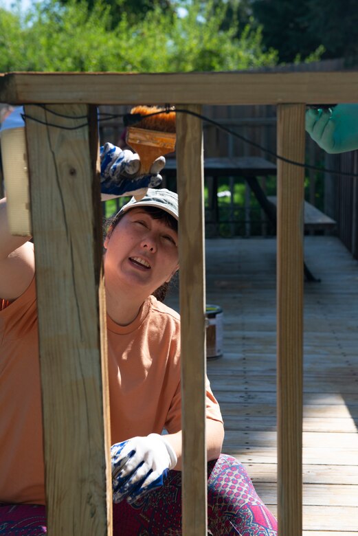 Michelle Butler, contract specialist, U.S. Army Corps of Engineers, Omaha District, Environmental Remediation , stains the banister of a deck during the 2021 Paint-A-Thon, Aug. 21, 2021, Omaha, Neb.
