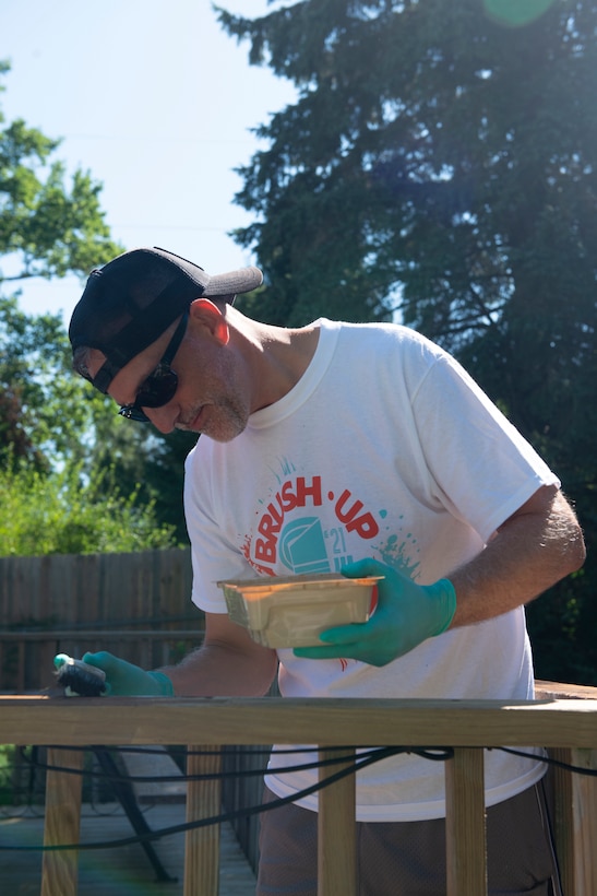 Adam Ashton, project manager, U.S. Army Corps of Engineers , Omaha District, Special Projects Division, puts stain on a banister during the 2021 Paint-A-Thon, Aug. 21, 2021, Omaha, Neb.