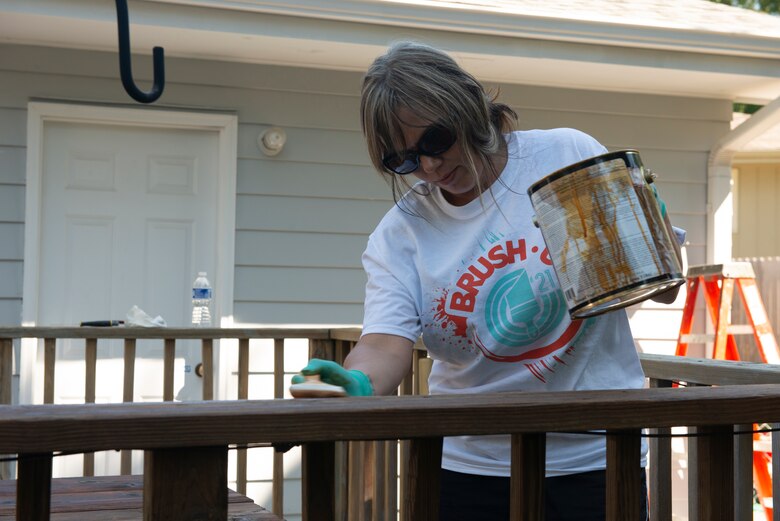 Susie Brunotte, program manager, U.S. Army Corps of Engineers, Omah District, Fuels Department, stains the banister of the deck during the 2021 Paint-A-Thon, Aug. 21,