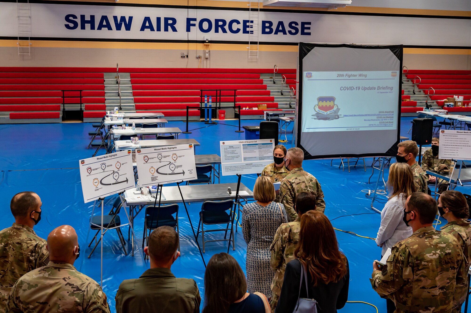 A photo of Airmen briefing a group of distinguished visitors.