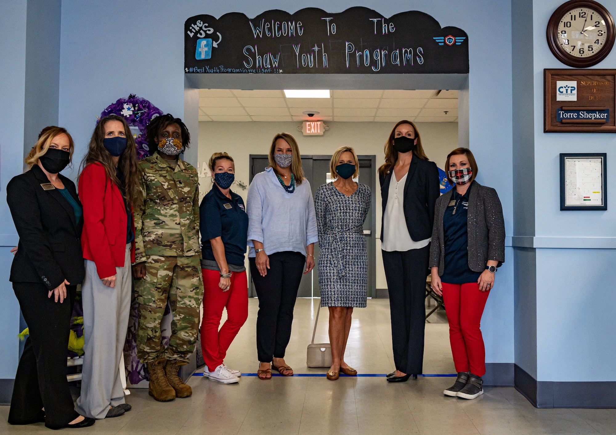 A photo of a group of visitors standing in the doorway of the Shaw Youth Center.