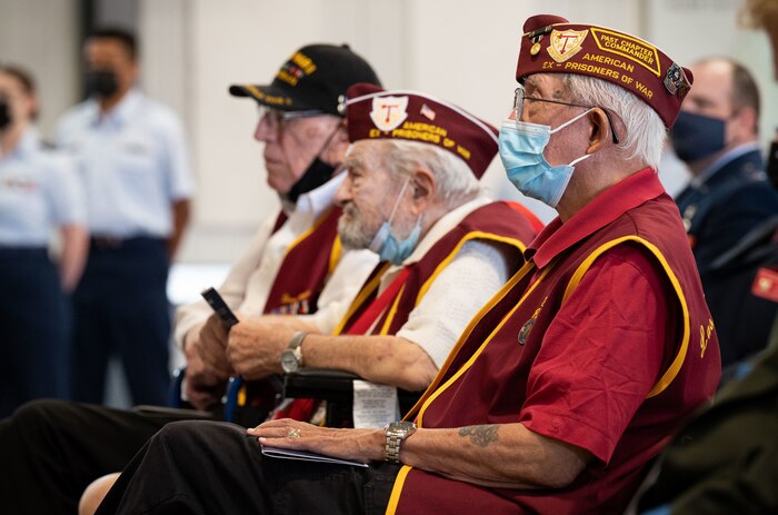 Former Prisoners of War sit in the front row of a ceremony
