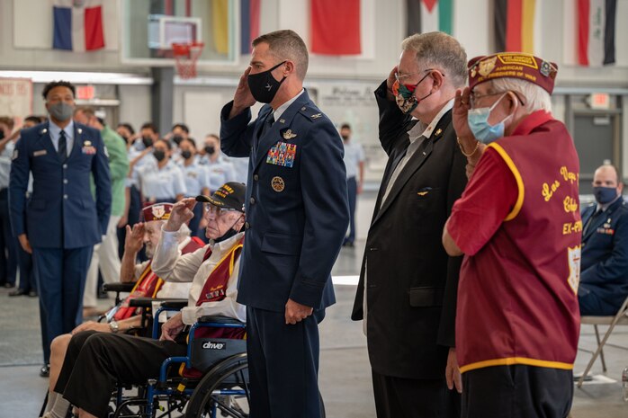 Col. Dyer salutes alongside four former Prisoners of War