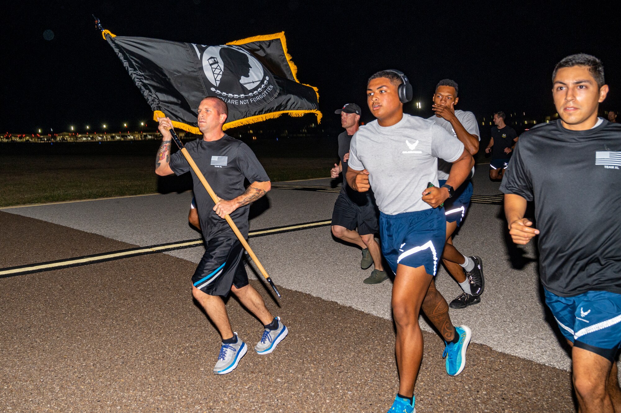 Members of team XL participate in a 5k run while carrying the POW/MIA flag through Laughlin Air Force Base, Texas on Sept. 17, 2021, and flightline  to remember those who were taken prisoner or have gone missing in action in conflicts. It honors those who were prisoners of war and those who are still missing in action. It is most associated with those who were POWs during the Vietnam War. (U.S. Air Force photo by Airman 1st Class David Phaff)