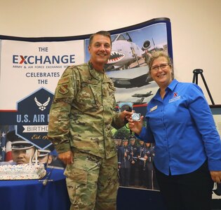 U.S. Air Force Col. Mike Zuhlsdorf, Joint Base Anacostia-Bolling and 11th Wing commander, presents Ann Marie Wachtel, Main Store Manager, The Exchange, with a commander’s coin during the Air Force 74th birthday cake cutting event. Col. Zuhlsdorf gave Wachtel the commander’s coin for her hard work and dedication in serving the Air Force.