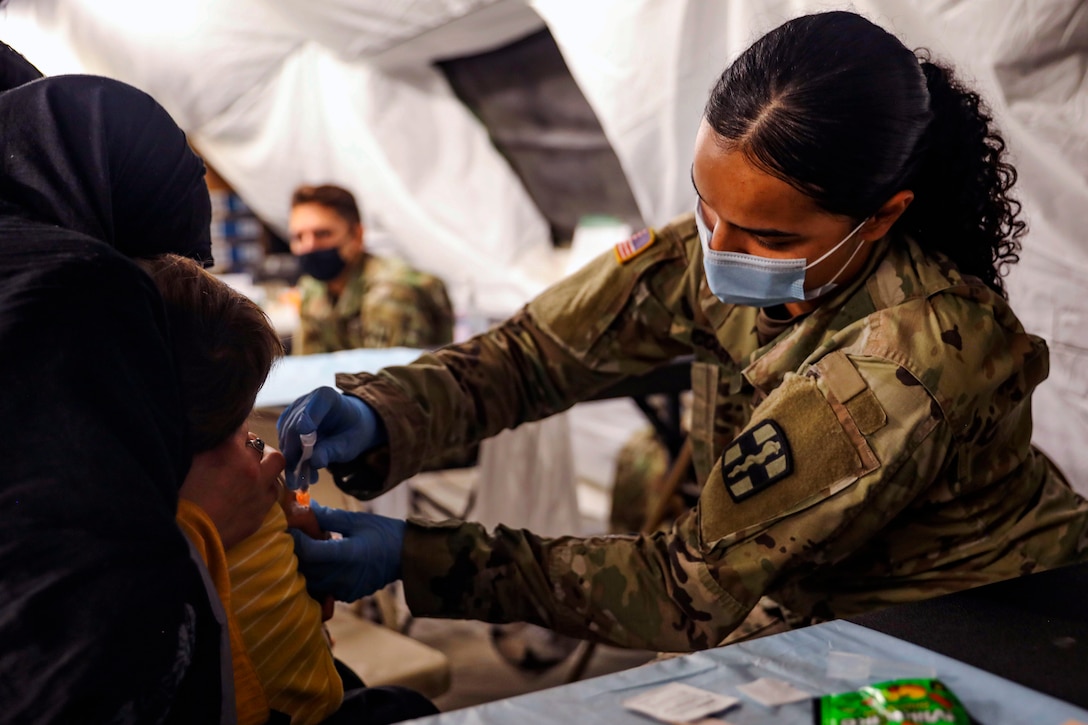 A soldier gives a shot to a child.