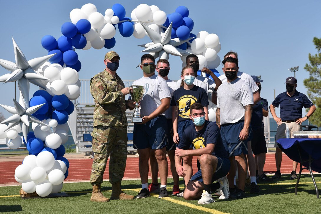 U.S. Air Force Col. Matthew Reilman, 17th Training Wing commander, presents the 17th Communications Squadron with the winning trophy for Wing Sports Day on Goodfellow Air Force Base, Sept. 17, 2021. Over 150 members participated in the wing-wide sports event. (U.S. Air Force photo by Senior Airman Jermaine Ayers)