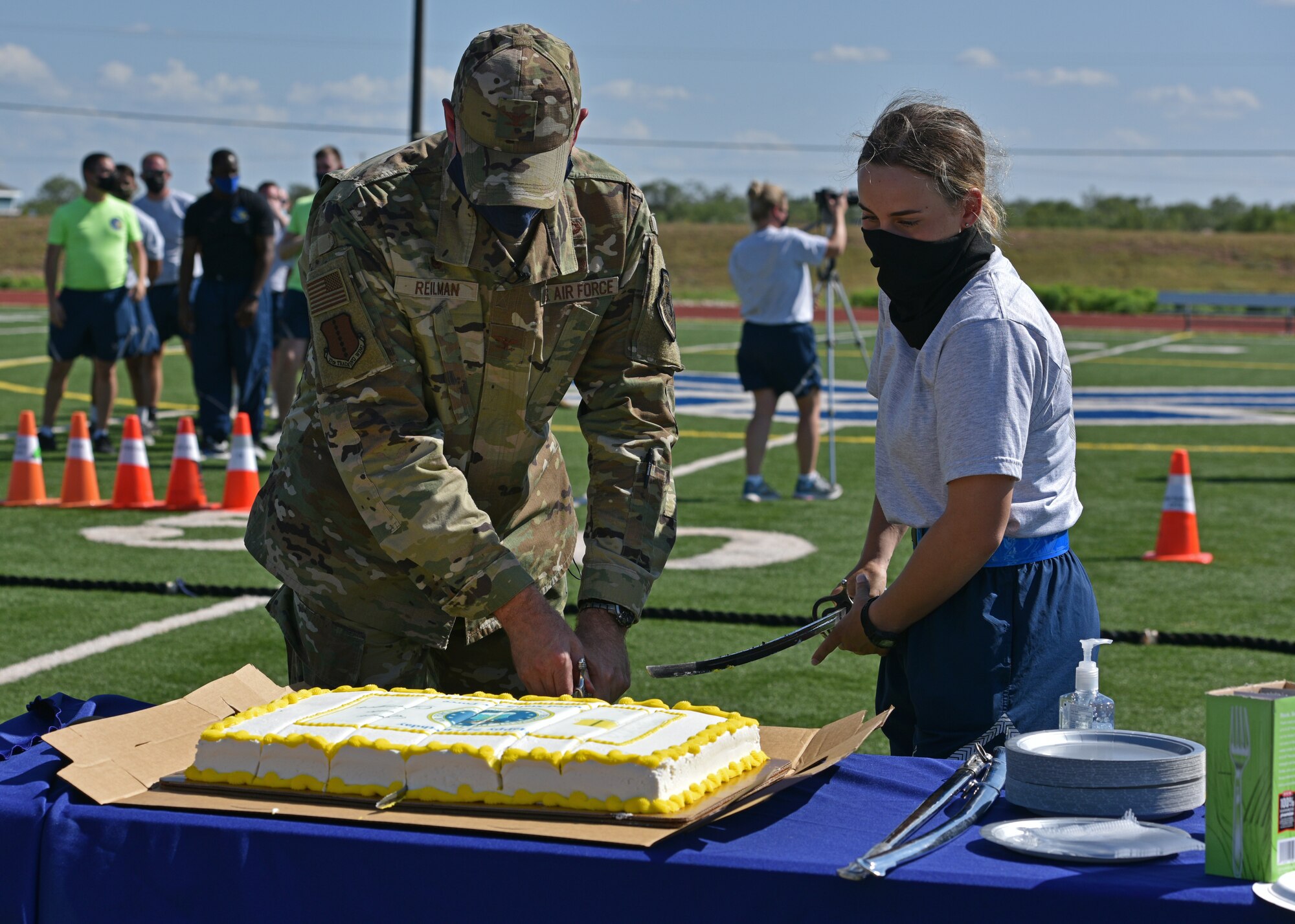 U.S. Air Force Col. Matthew Reilman, 17th Training Wing commander, and Airman 1st Class Gianna Grimaldi, 315th Training Squadron student, cut the cake at the end of Wing Sports Day on Goodfellow Air Force Base, Texas, Sept. 17, 2021. This momentous occasion is a part of a long-standing tradition that involves a senior ranking military member cutting the cake with the youngest Airman. (U.S. Air Force photo by Senior Airman Ashley Thrash)