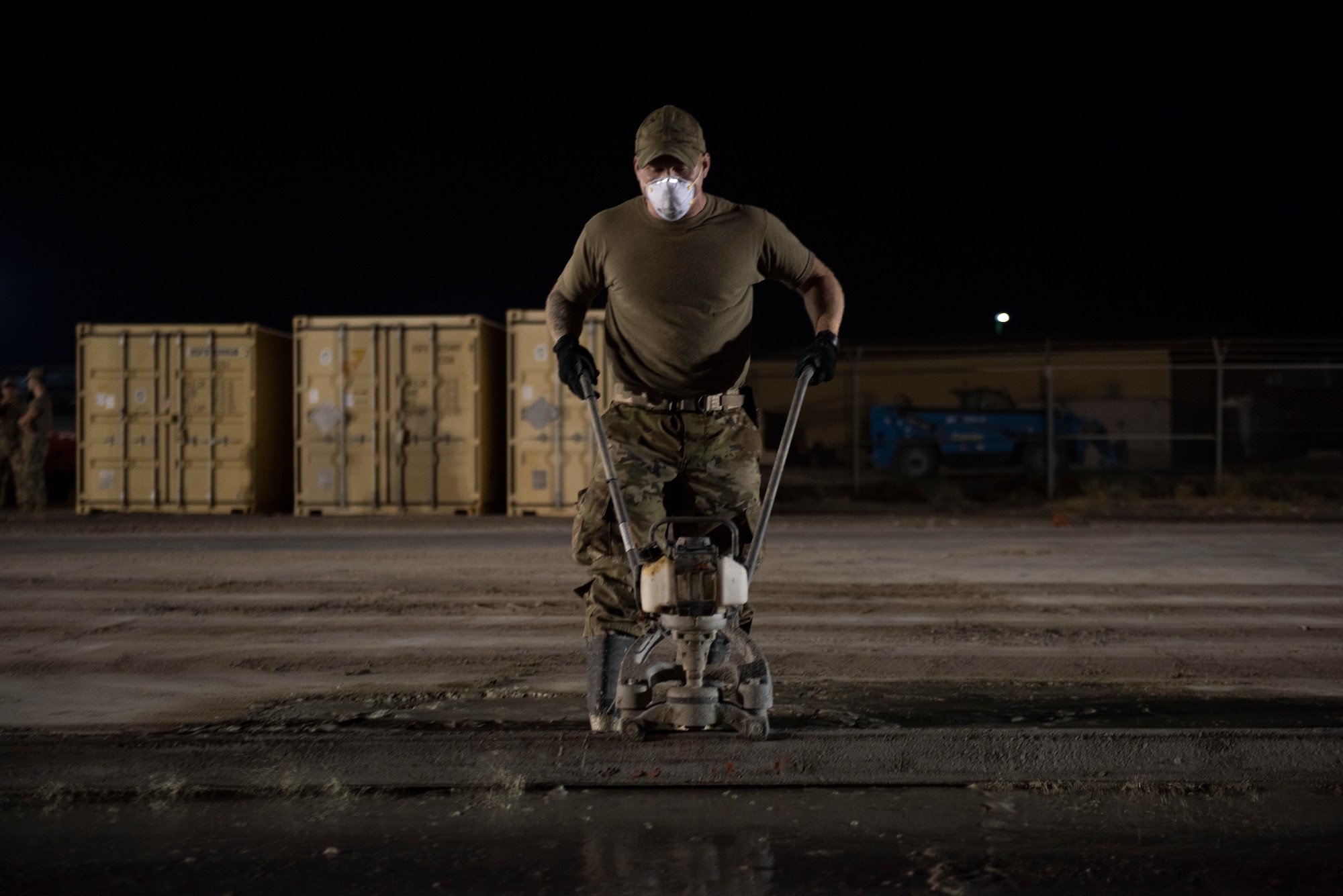 A photo of an Airman leveling concrete