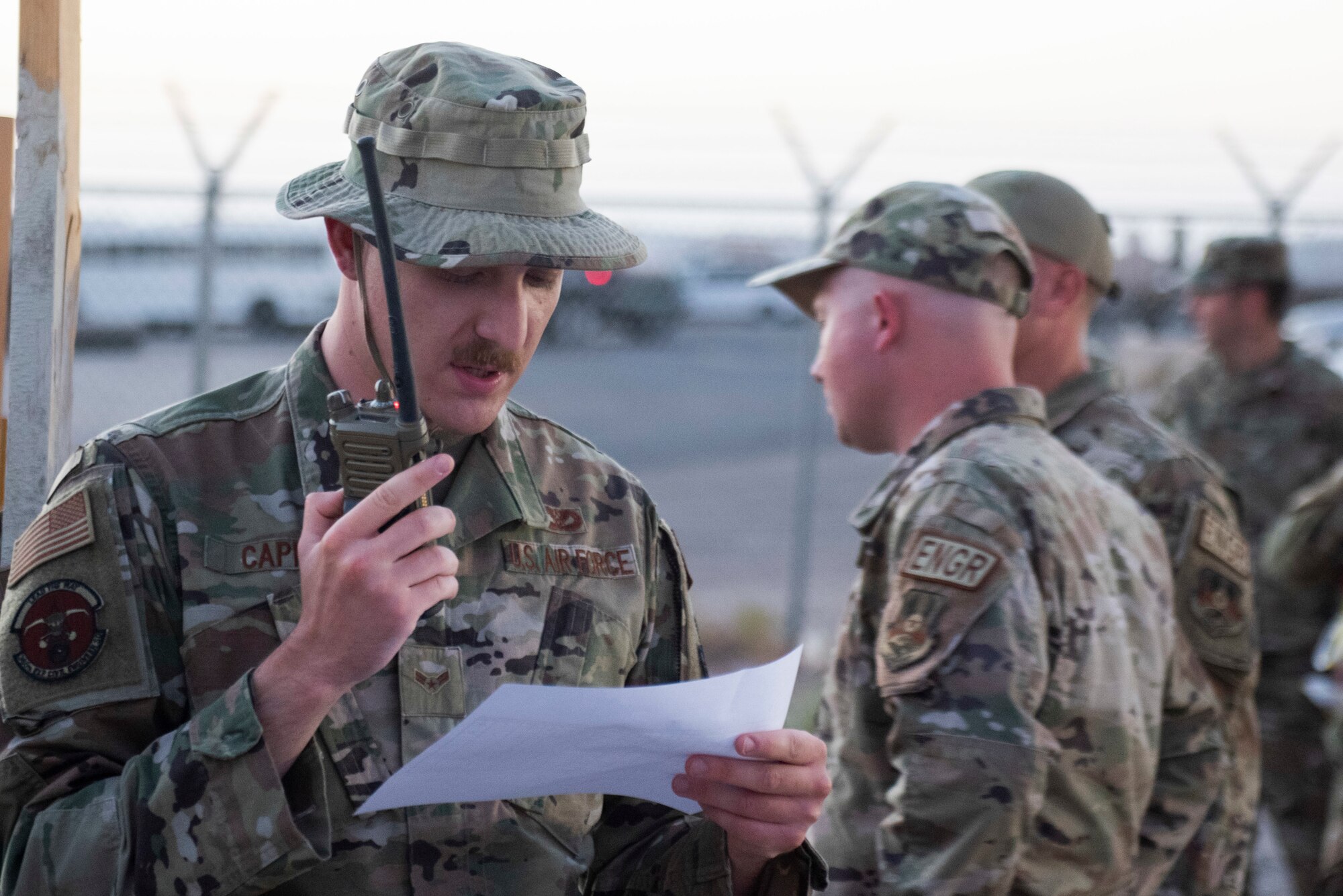 A photo of an Airman speaking into a radio