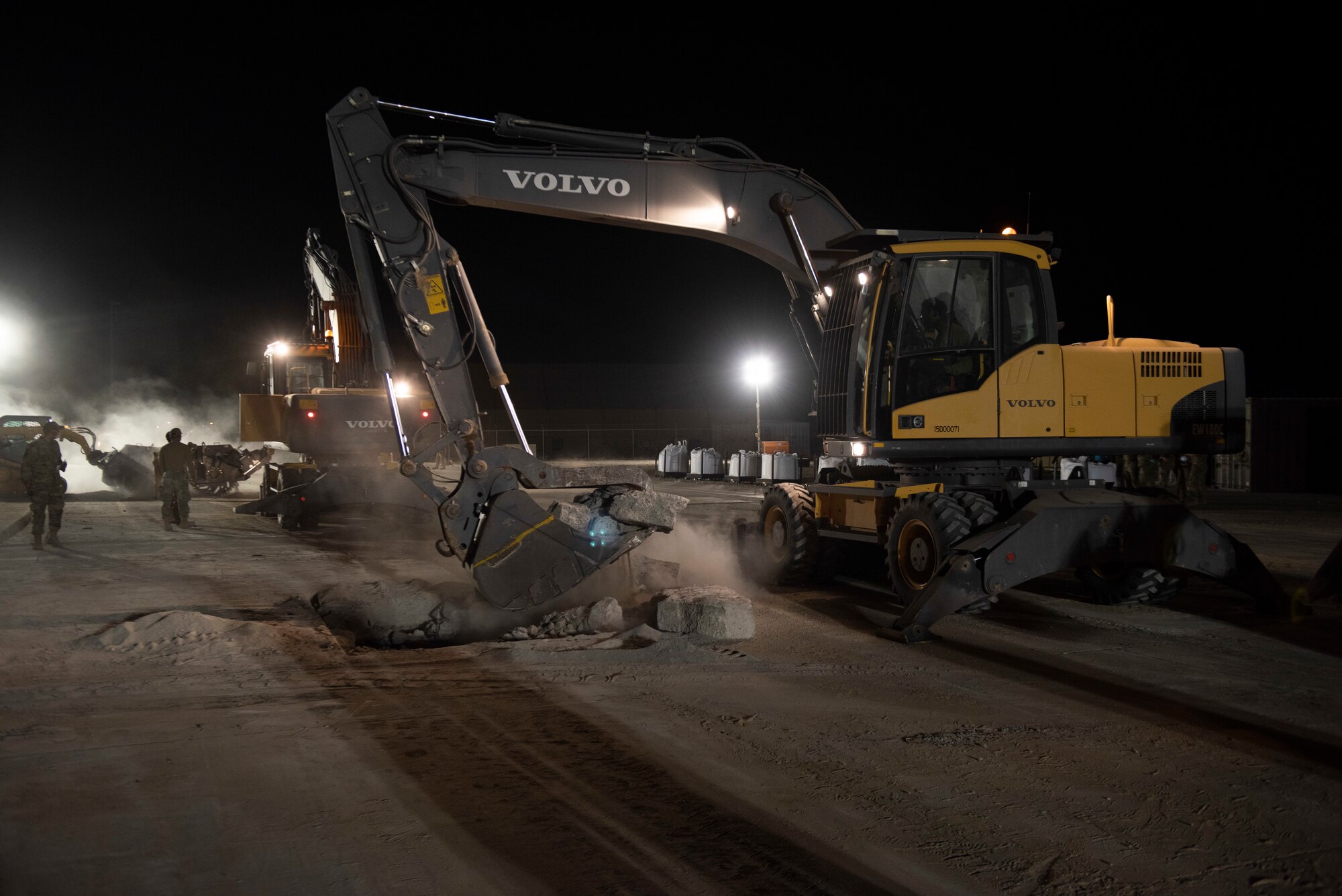 A photo of a excavator picking up debris