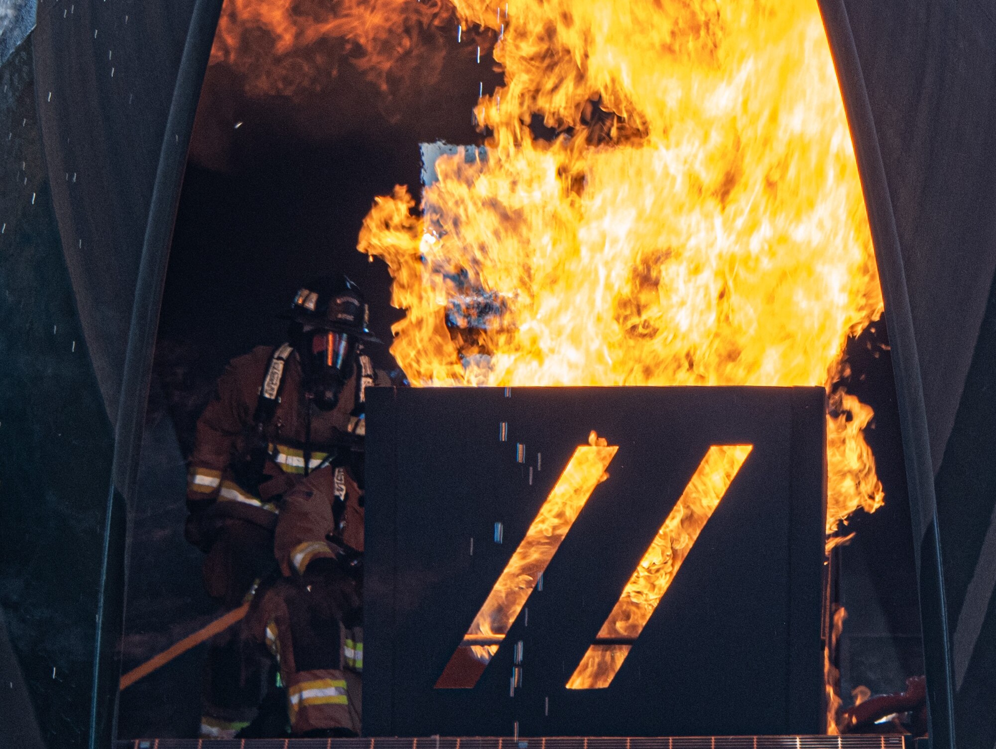 Reserve firefighters from the 419th Civil Engineer Squadron enter a downed aircraft during a live-fire burn to simulate the rescue of unaccounted for passengers