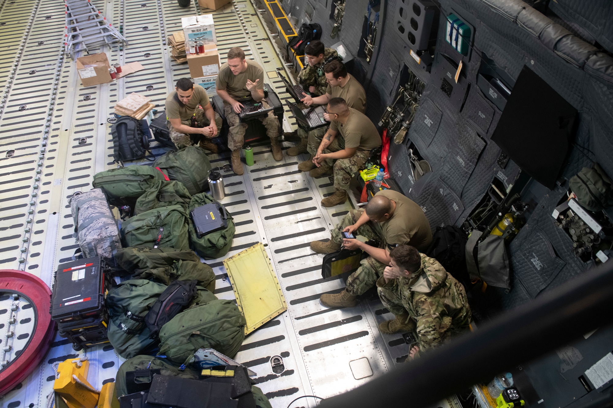 730th Air Mobility Squadron members take a break and check C-5M Super Galaxy guidance at Yokota Air Base, Japan, Sept. 15, 2021. Through a special request to Pacific Air Forces, the 730th AMS was able to utilize a C-5M for familiarization training. (U.S. Air Force photo by Staff Sgt. Joshua Edwards)