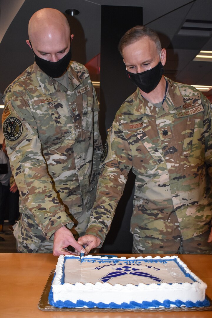 Service members cut cake for AF birthday celebration.