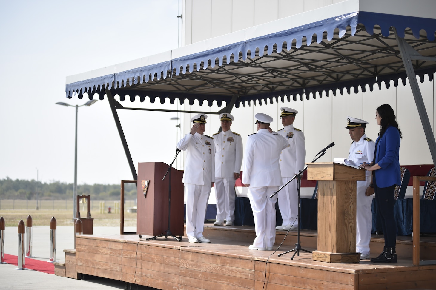 Cmdr. Michael Dwan, left, salutes Cmdr. Frederick Hettling, center, signifying that Cmdr. Hettling has assumed command as Commander, U.S. Aegis Ashore Missile Defense System Romania (USAAMDSRO), at a change of command ceremony onboard Naval Support Facility Devesulu, Romania, Sept. 17.