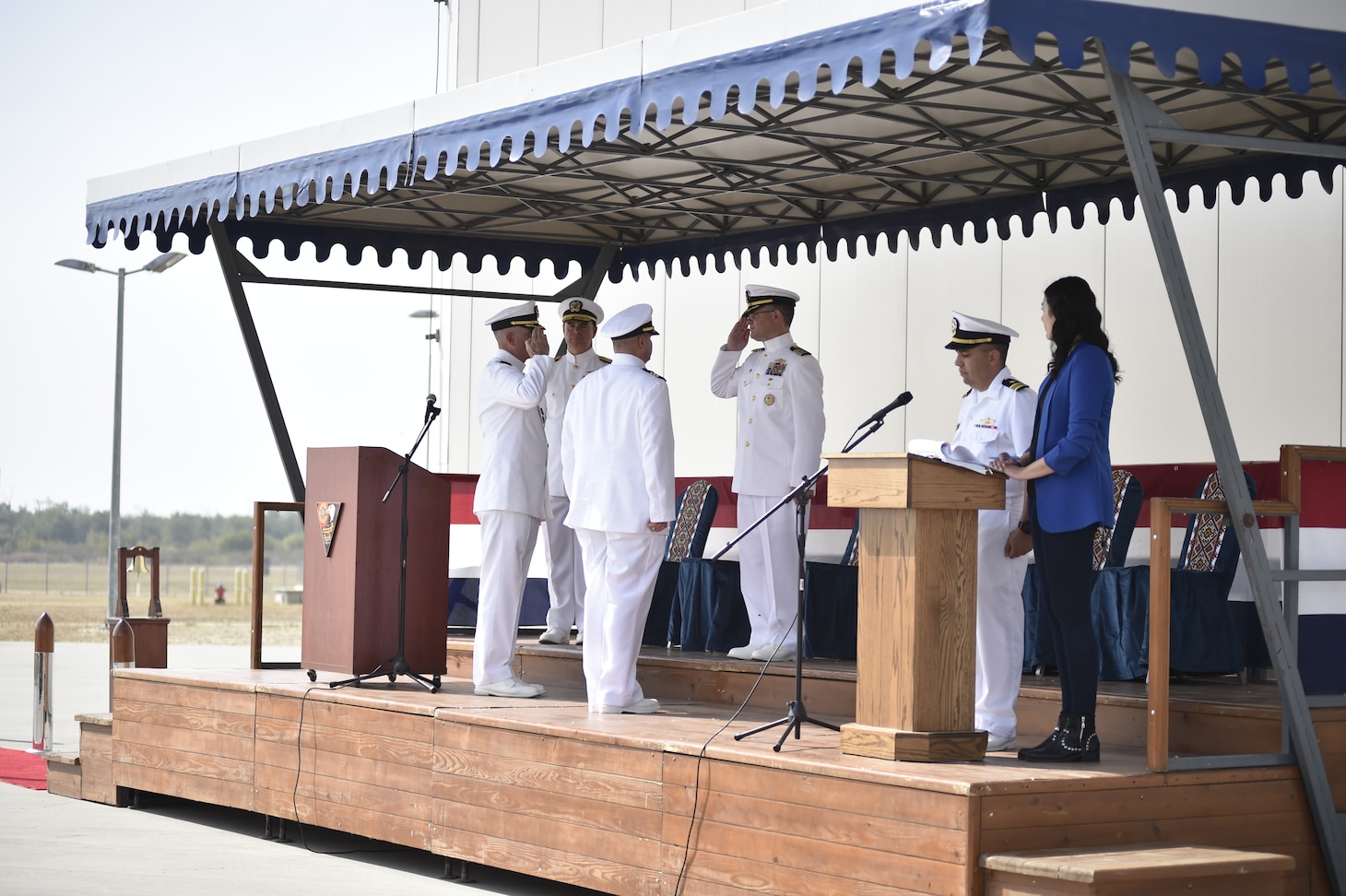 Cmdr. Frederick Hettling, center left, salutes Capt. Jonathan Lipps, commander, Task Force (CTF) 64, center, signifying that he has assumed command as Commander, U.S. Aegis Ashore Missile Defense System Romania (USAAMDSRO), at a change of command ceremony onboard Naval Support Facility Devesulu, Romania, Sept. 17.