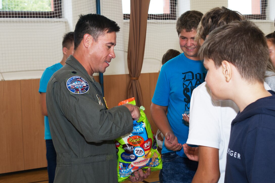 Photo of people cutting cake with a sword.