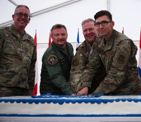 Photo of people cutting cake with a sword.