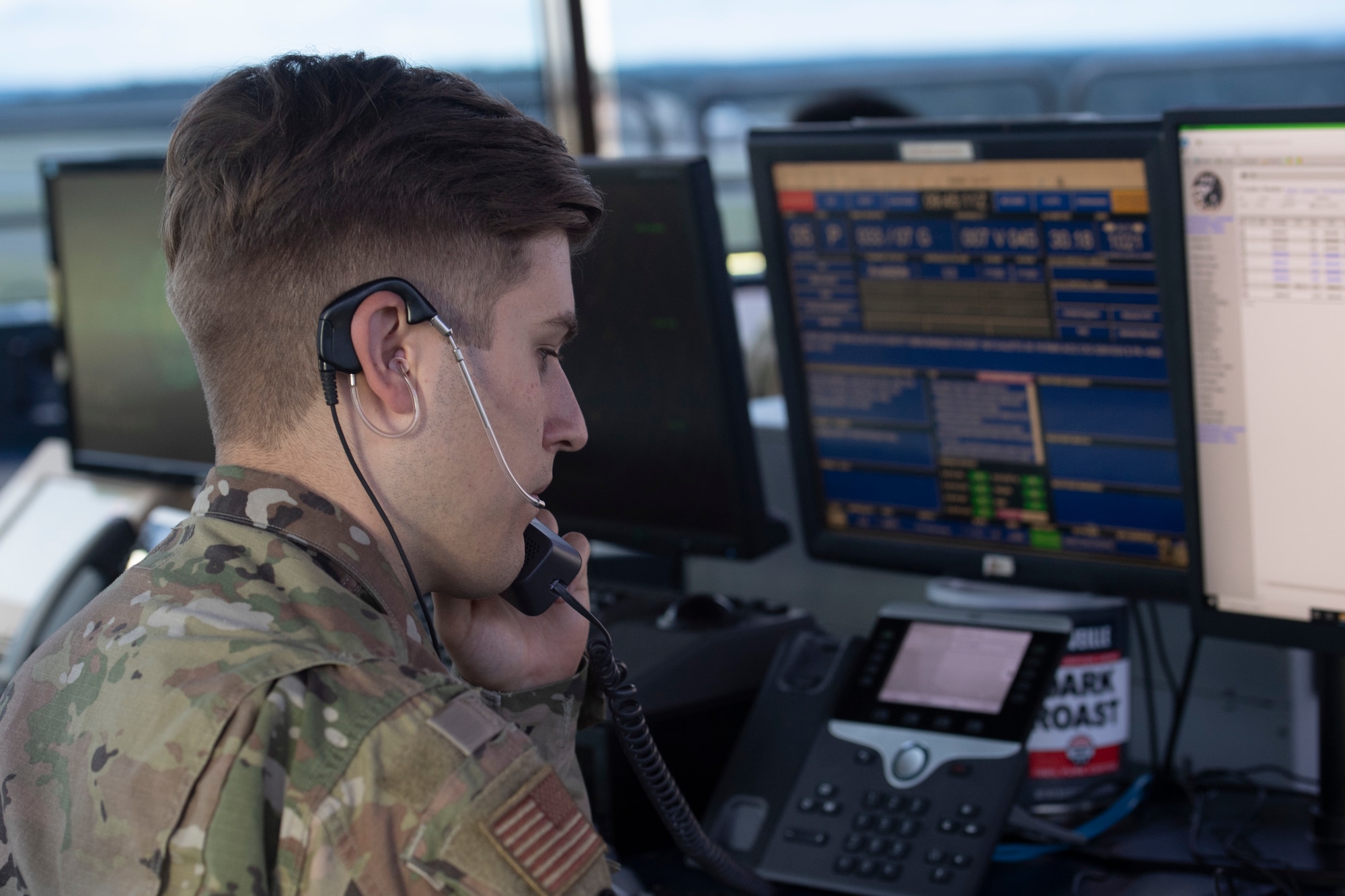 U.S. Air Force Staff Sgt. Austin Rood, 52nd Operations Support Squadron air traffic control specialist, discusses information about an incoming flight at Spangdahlem Air Base, Germany, Aug. 23, 2021.