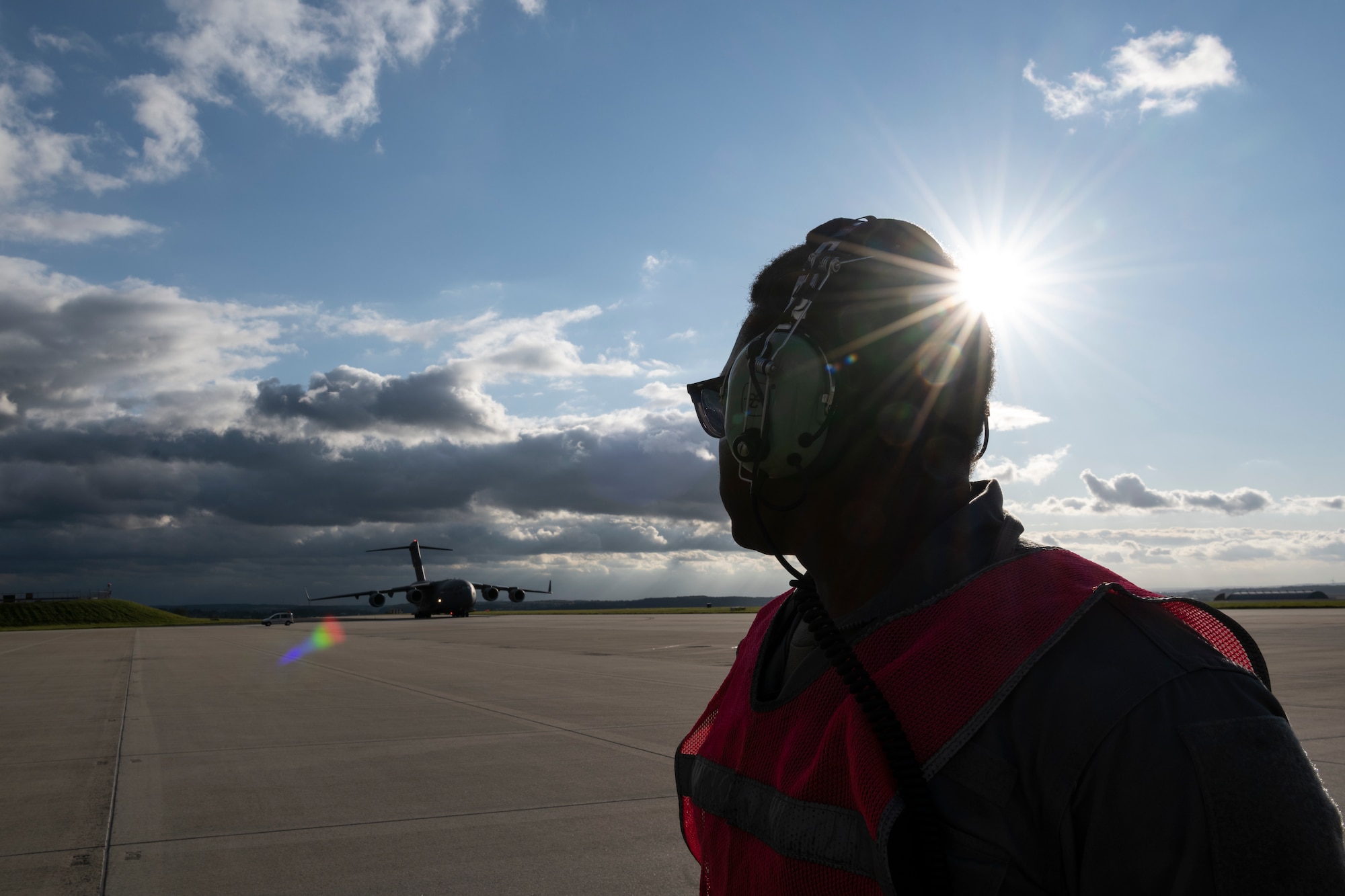 U.S. Air Force Senior Airman Leonard Bond, 726th Air Mobility Squadron aircraft electrical and environmental technician, waits to marshal a U.S. Air Force C-17 Globemaster III cargo aircraft assigned to Joint Base Charleston, South Carolina, after it landed on Spangdahlem Air Base, Germany, Aug. 27, 2021.