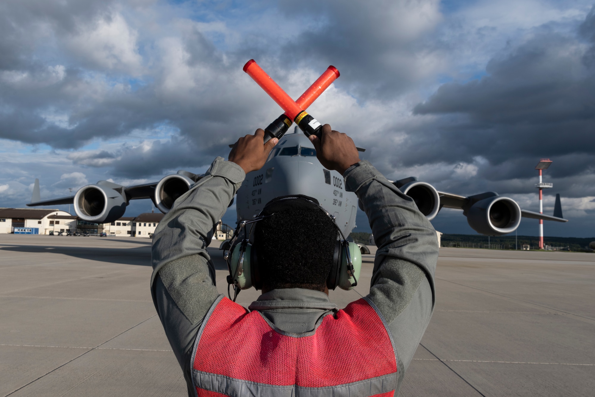 U.S. Air Force Senior Airman Leonard Bond, 726th Air Mobility Squadron aircraft electrical and environmental technician, marshals a U.S. Air Force C-17 Globemaster III cargo aircraft assigned to Joint Base Charleston, South Carolina, after it landed on Spangdahlem Air Base, Germany, Aug. 27, 2021.