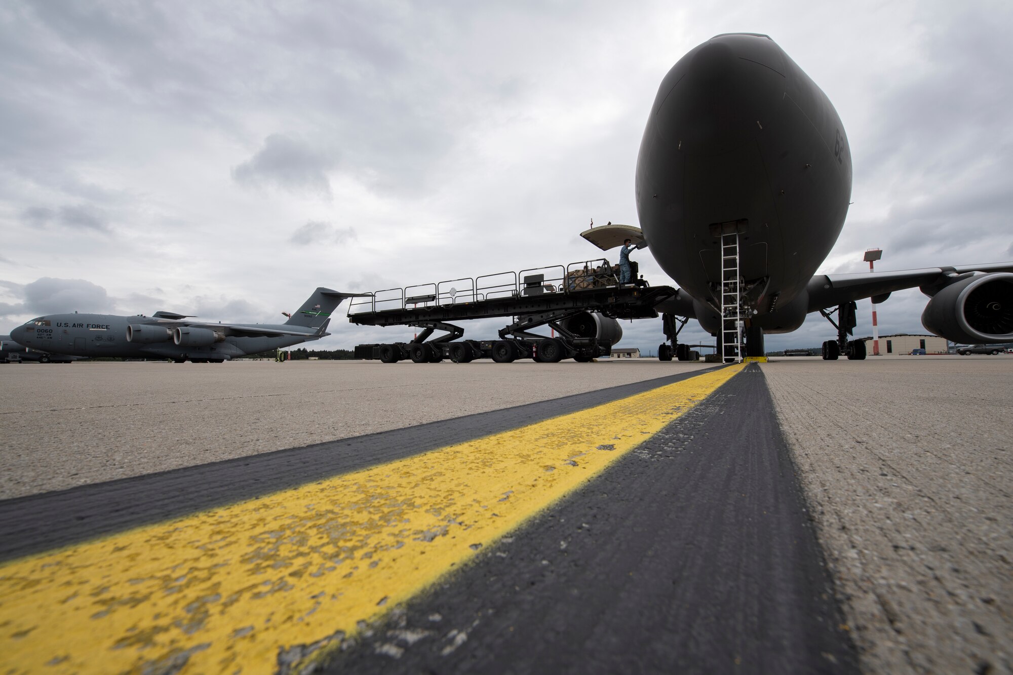 Republic of Singapore Air Force personnel and a U.S. Air Force Airman from the 726th Air Mobility Squadron load cargo onto a RSAF A330 Multi-Role Tanker Transport aircraft.