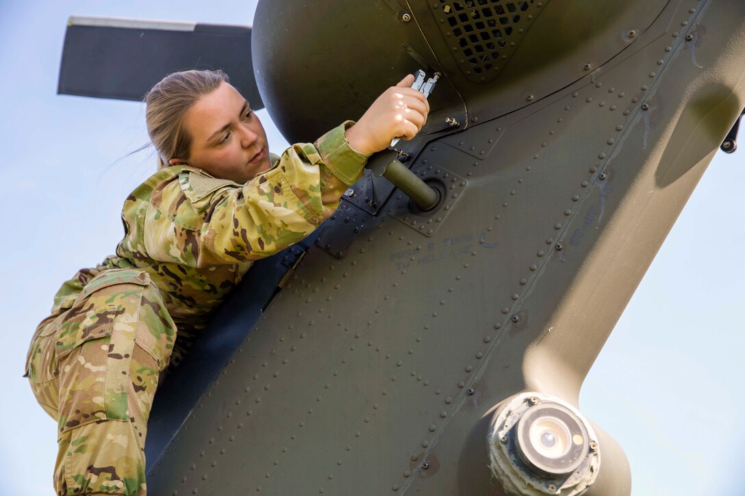 A soldier performs maintenance on an aircraft.