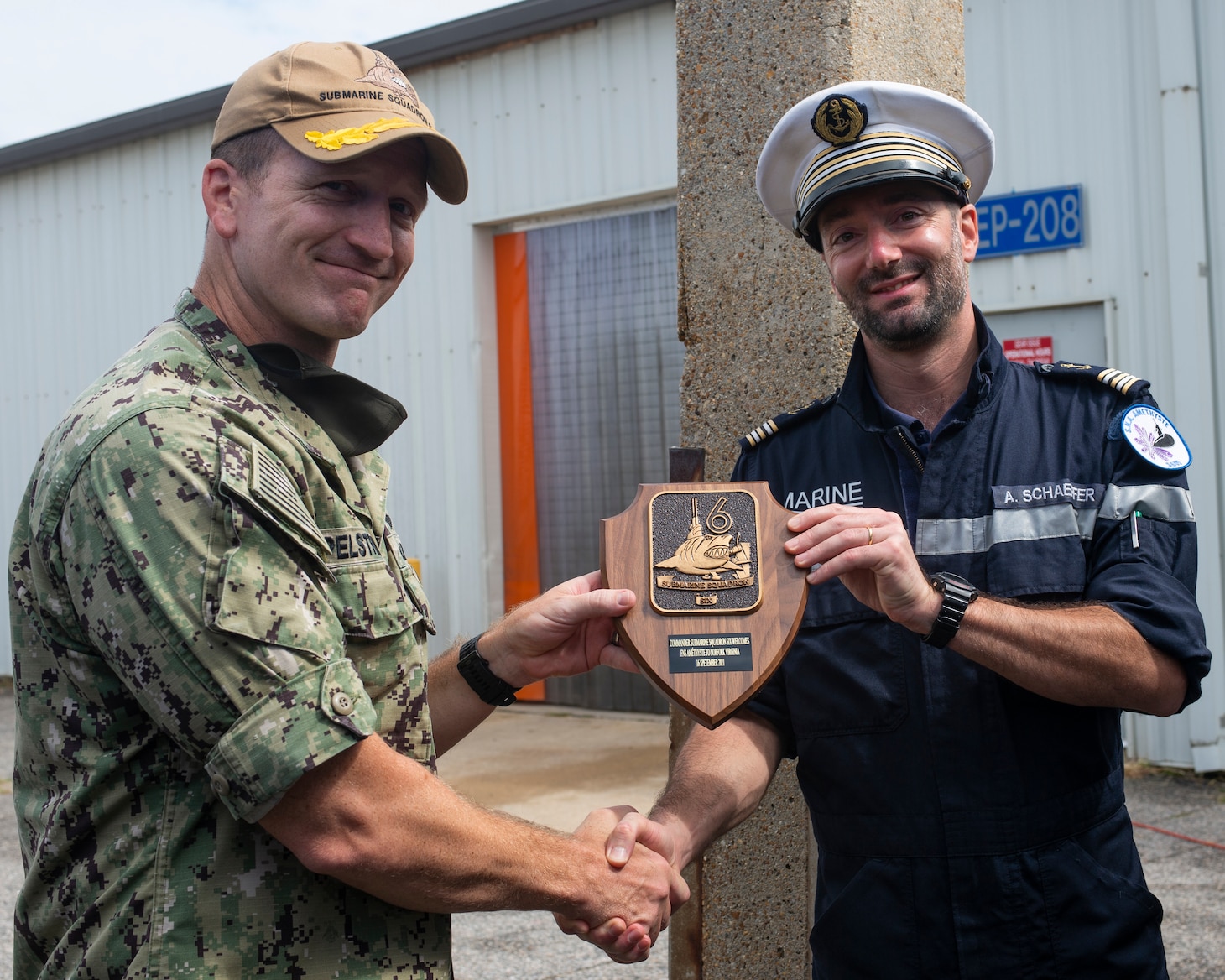 Capt. Jeremy Pelstring, assigned to Commander, Submarine Squadron 6, exchange gifts with Cmdr. Aymeric Schaeffer, commanding officer of the nuclear-powered French submarine FNS Amethyste (S605), at Naval Station Norfolk, Sept. 17, 2021.