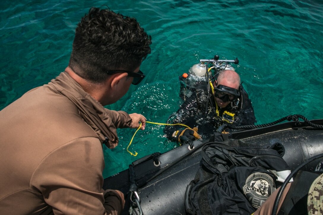 U.S. Navy Seabees with Underwater Construction Team 2, dive from a Marine Corps Combat Rubber Reconnaissance Craft during exercise Poseidon’s Watchtower off the coast of Ukibaru Island, Okinawa, Japan, June 9, 2021. Marines with 3rd Marine Logistics Group and Sailors with Naval Mobile Construction Battalion 4 and UCT-2 conducted a reconnaissance of the island to hone their skills in assessing terrain for suitability of supporting maritime operations. NMCB-4 is forward deployed throughout the Indo-Pacific region and United States, ready to support major combat operations, theater security, humanitarian assistance and disaster relief operations. UCT-2 provides a capability to support a Fleet Marine Force amphibious assault, subsequent combat service support ashore, and construction, inspection, repair and maintenance of ocean facilities in support of Navy and Marine Corps operations.