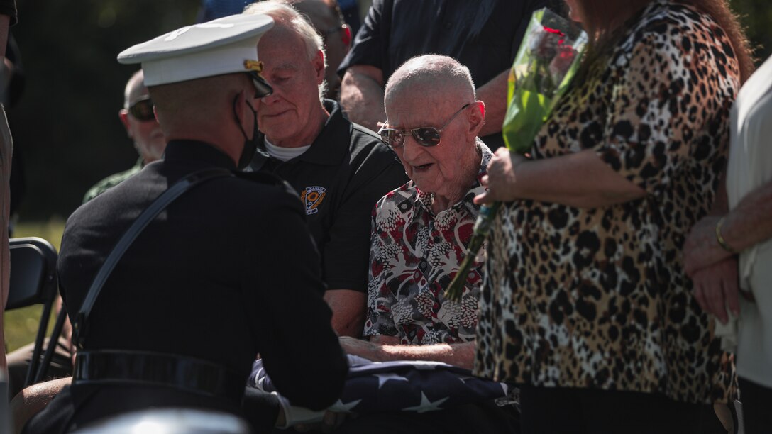 U.S. Marine Corps Maj. Francisco Pietri, operations officer with Headquarters Company, Combat Logistics Regiment 4, 4th Marine Logistics Group, gives a folded American flag to Don Stair, a family member of Pfc. Glenn White, in Emporia, Kan., Sept. 18, 2021. In November 1943, White was a member of 1st Battalion, 6th Marine Regiment, 2d Marine Division, when he was killed in action in the Tarawa Atoll of the Gilbert Islands during War World II. (U.S. Marine Corps photo by Lance Cpl. Jacqueline C. Arre)