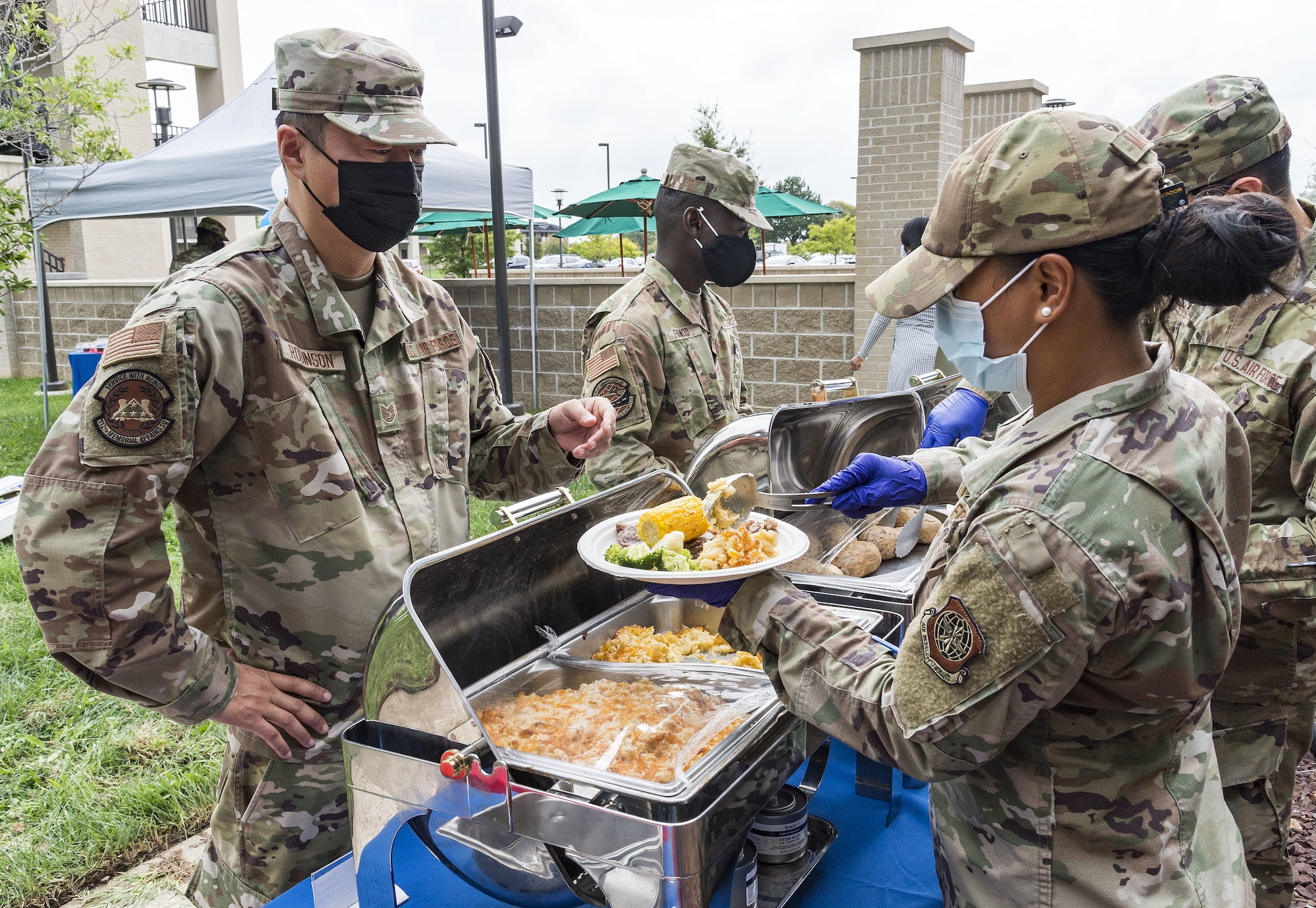 Staff Sgt. Miriam Malapit, right, 436th Force Support Squadron storeroom manager, serves food to Tech. Sgt. Kyle Robinson, left, 512th Mortuary Affairs Squadron mortuary technician at the Patterson Dining Facility on Dover Air Force Base, Delaware, Sept. 17, 2021. The DFAC held a picnic-style lunch commemorating the grand reopening, as well as a cake cutting celebrating the Air Force’s 74th birthday. (U.S. Air Force photo by Roland Balik)