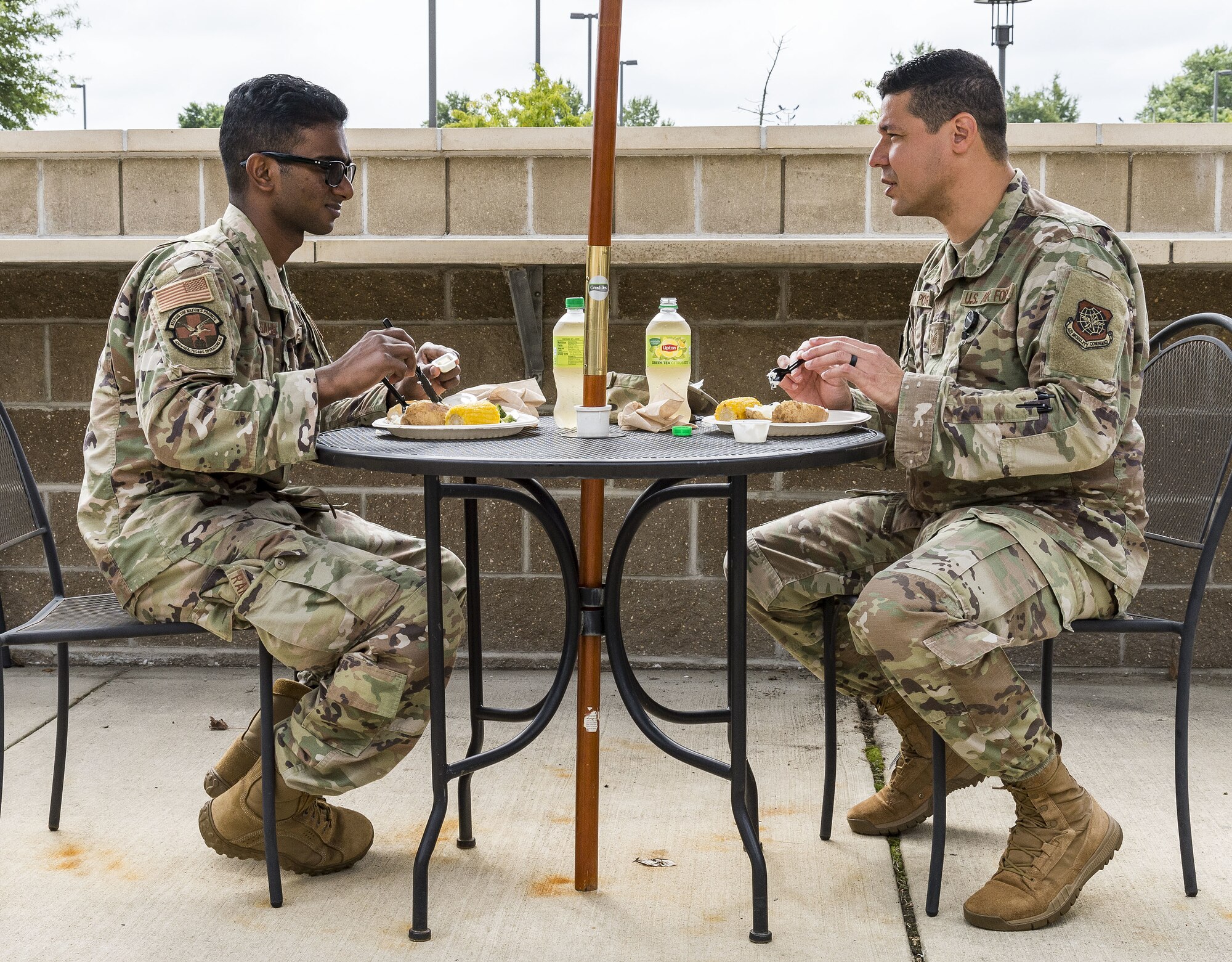 Staff Sgt. Yaspaul Rampersaud, left, 436th Operational Medical Readiness Squadron immunizations noncommissioned officer in charge, and Tech. Sgt. Flavio Porto, right, 436th OMRS medical services flight chief, eat lunch outside the Patterson Dining Facility on Dover Air Force Base, Delaware, Sept. 17, 2021. The DFAC held a picnic-style lunch commemorating the grand reopening, as well as a cake cutting celebrating the Air Force's 74th birthday. (U.S. Air Force photo by Roland Balik)