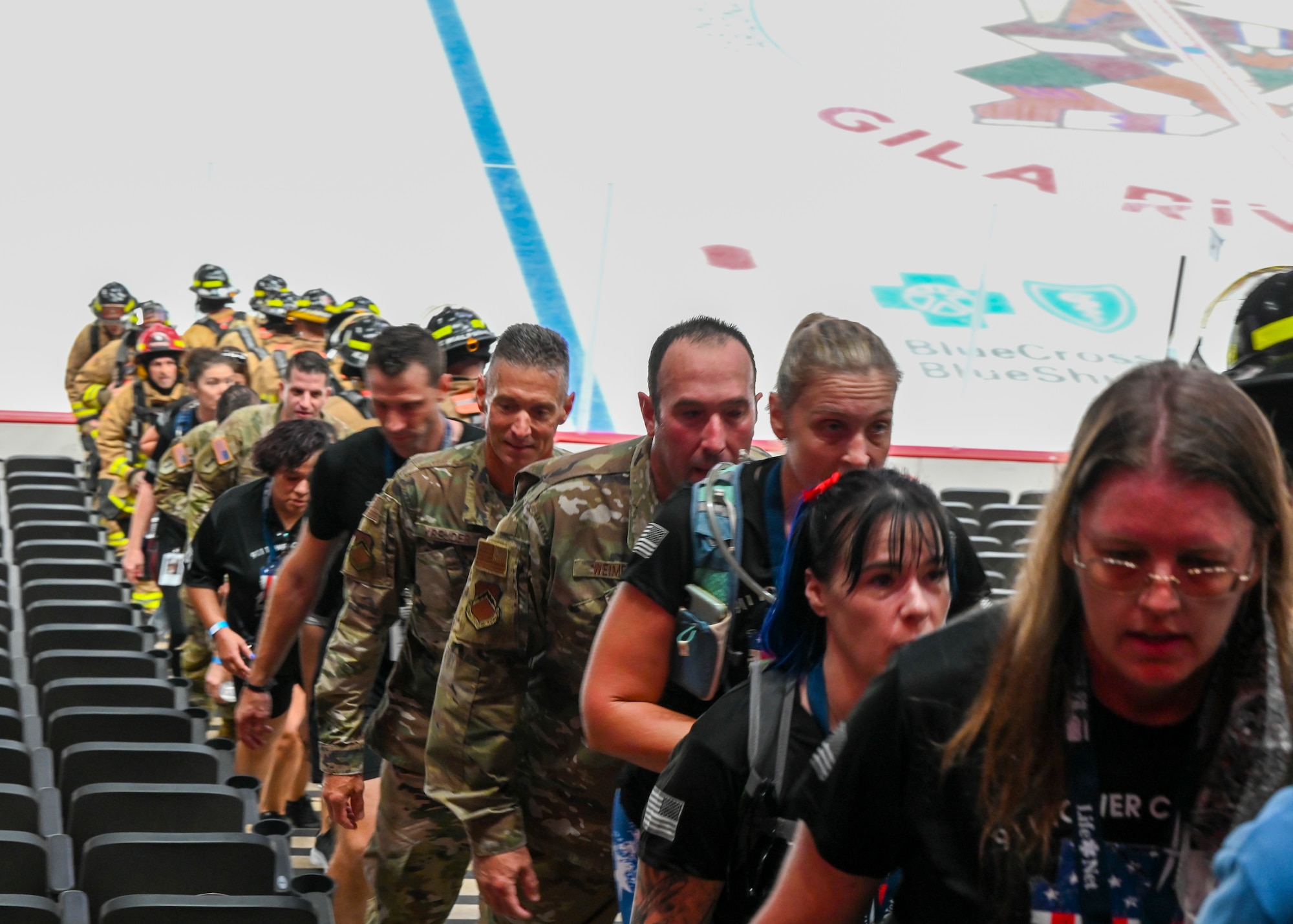Brig. Gen. Gregory Kreuder, 56th Fighter Wing commander (left in Operational Camouflage Pattern uniform), and Chief Master Sgt. Daniel Weimer (right in OCP uniform), 56th Fighter Wing command chief, climb steps in the 9/11 Tower Challenge at Gila River Arena Sept. 7, 2021, in Glendale, Arizona.