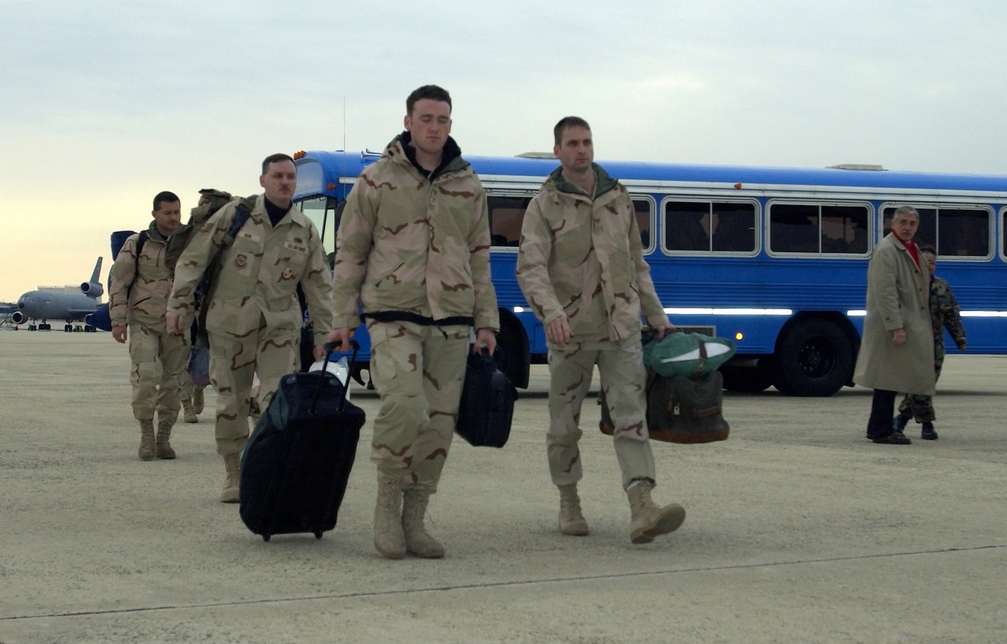US Air Force (USAF) Airmen from the 621st Air Mobility Operations Group (AMOG), McGuire Air Force Base (AFB), New Jersey (NJ), move from their bus toward an aircraft enroute to a CENTCOM (US Central Command) Area of Responsibility (AOR).