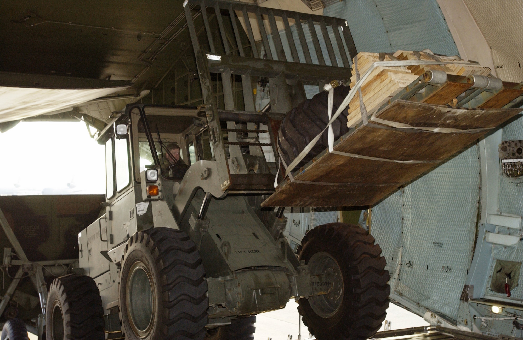 US Air Force (USAF) Airmen from the 621st Air Mobility Operations Group (AMOG), McGuire Air Force Base (AFB), New Jersey (NJ), load cargo with a John Deere 544E10K Advance Terrain forklift into a C-5 Galaxy in preparation for deployment in support of Operation ENDURING FREEDOM.