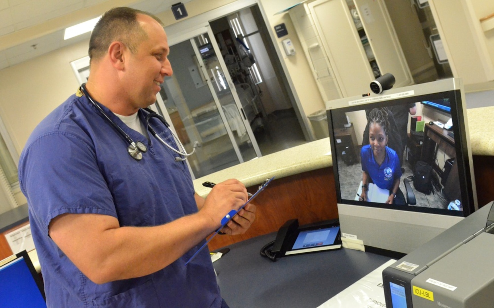 Lt. Michael White, a nurse at Naval Hospital Jacksonville’s intensive care unit, uses telehealth to discuss patient statuses and recommendations with Tiffany Ingram, a nurse at Naval Medical Center San Diego. Telehealth is the use of telecommunications and information technologies to provide health assessment, diagnosis, treatment, consultation, education, and health-related information across distances. White, a native of Boise, Idaho, says, “Telehealth provides us the opportunity to access those critical care resources to help mitigate staffing shortages. From a nursing standpoint, it gives us a second pair of critical care nursing eyes on the patient data to potentially catch any signs or symptoms that might get missed by the assigned nurse.” (U.S. Navy photo by Jacob Sippel, Naval Hospital Jacksonville/Released).