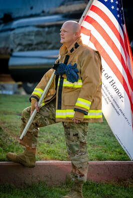 U.S. Air Force Col. Jocelyn Schermerhorn, 1st Special Operations Wing commander, grabs an American flag to take on a 9/11 Memorial Ruck