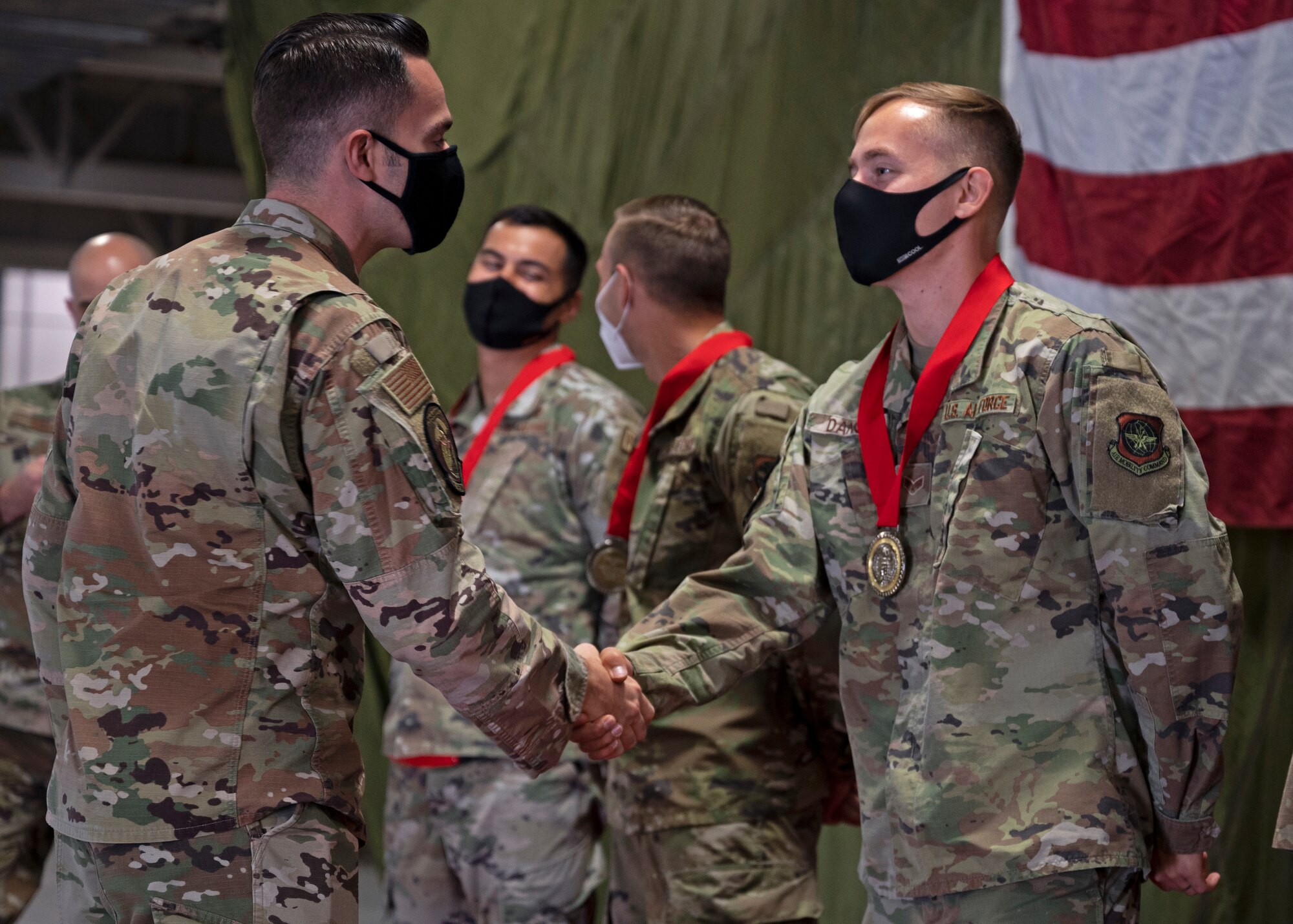 U.S. Air Force Maj. Wesley Ekwall, 62nd Aerial Port Squadron commander, congratulates Senior Airman Trenton Dancer, air freight operations specialist with the 62nd APS, after presenting him with his medal from the 2021 Pacific Air Forces (PACAF) Port Dawg Rodeo at Joint Base Lewis-McChord, Washington, Sept. 15, 2021. Dancer was one of six Airmen from the Eagle Port team to compete at the port rodeo in August; where the team brought home two first place event awards and the award for Top Port Dawg Team. (U.S. Air Force photo by Senior Airman Zoe Thacker)