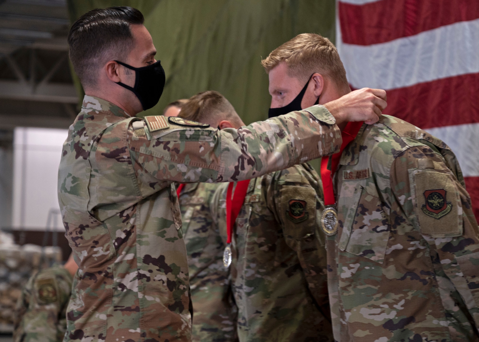 U.S. Air Force Maj. Wesley Ekwall, 62nd Aerial Port Squadron commander, presents a medal to Senior Airman Hayden Floyd, air freight journeyman with the 62nd APS, at Joint Base Lewis-McChord, Washington, Sept. 15, 2021. Floyd was one of six Airmen from the Eagle Port team to compete at the 2021 Pacific Air Forces (PACAF) Port Dawg Rodeo in August; where the team brought home two first place event awards and the award for Top Port Dawg Team. (U.S. Air Force photo by Senior Airman Zoe Thacker)