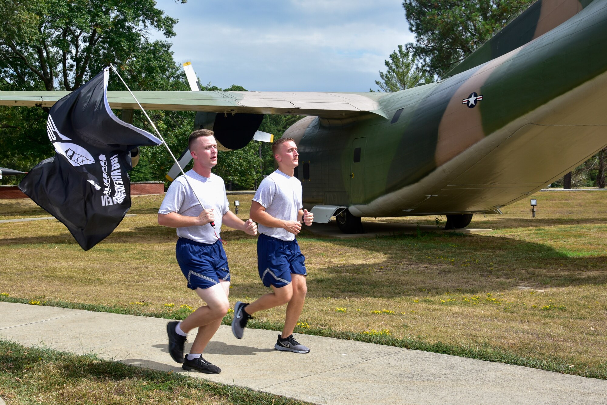 Airmen run carrying the POW/MIA flag