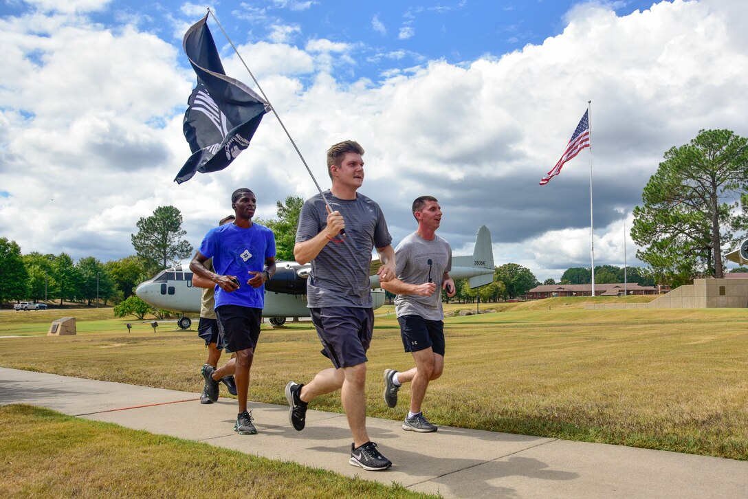 Airmen run carrying the POW/MIA flag
