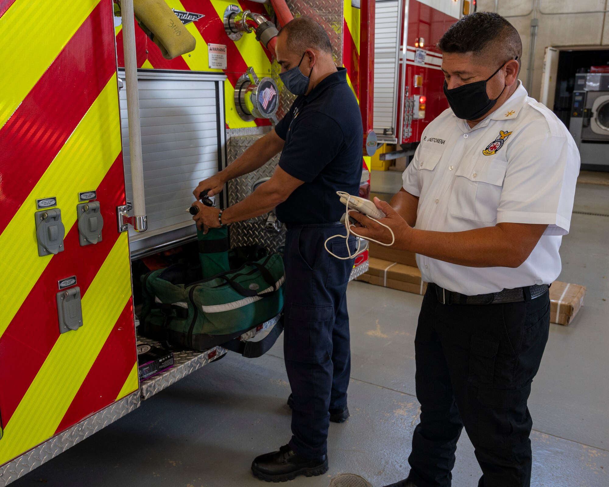 Francisco Grijalva, 47th Civil Engineering Squadron lead firefighter, inspects an oxygen canister while Raul Castorena, 47th CES assistant fire chief, checks other safety equipment on August 25, 2021 at Laughlin Air Force Base, Texas. Safety checks on firefighting equipment are essential for saving lives of both the firefighters and the lives they attempt to save. (U.S. Air Force Photo by Senior Airman Nicholas Larsen)