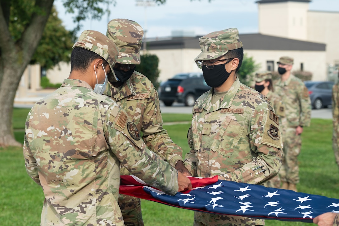 Dover Air Force Base Honor Guard members fold the American flag during a retreat ceremony commemorating National POW/MIA Recognition Day on Dover AFB, Delaware, Sept. 17, 2021. The ceremony also included the firing of a volley salute and the playing of taps. (U.S. Air Force photo by Mauricio Campino)