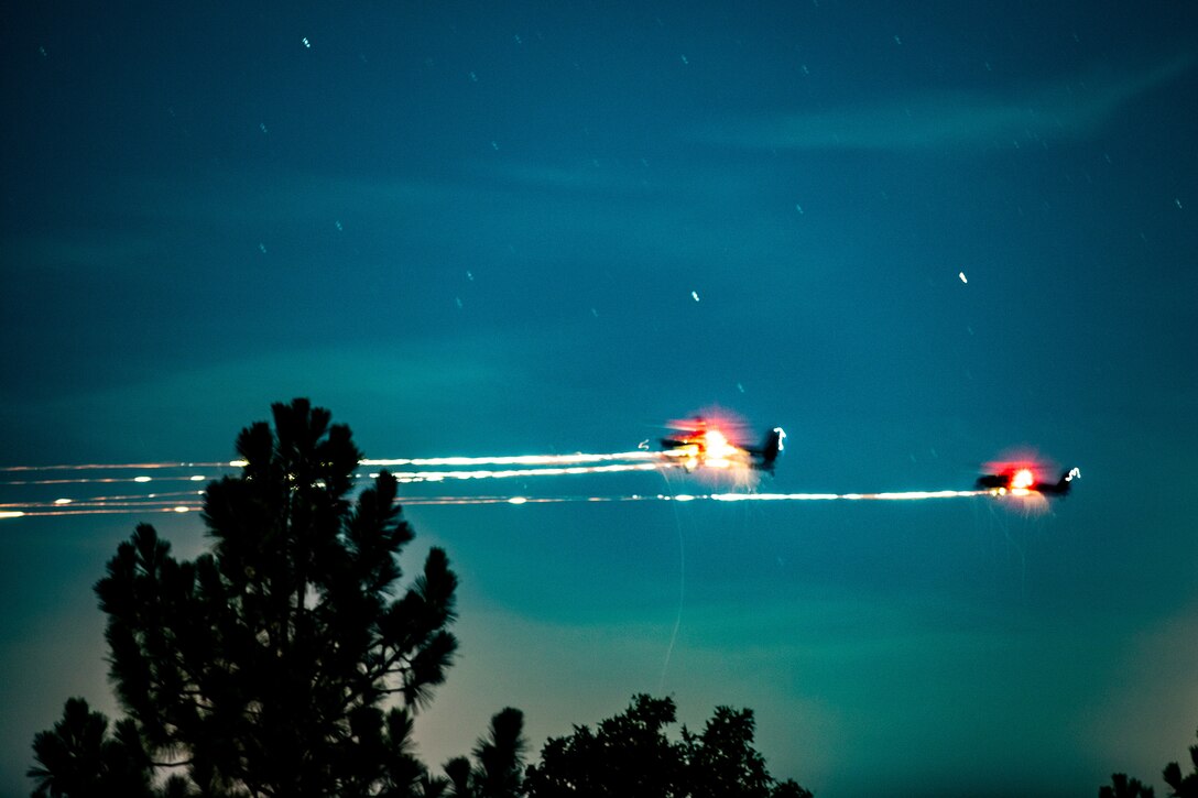 Two aircraft fire weapons in a dark blue starry sky.