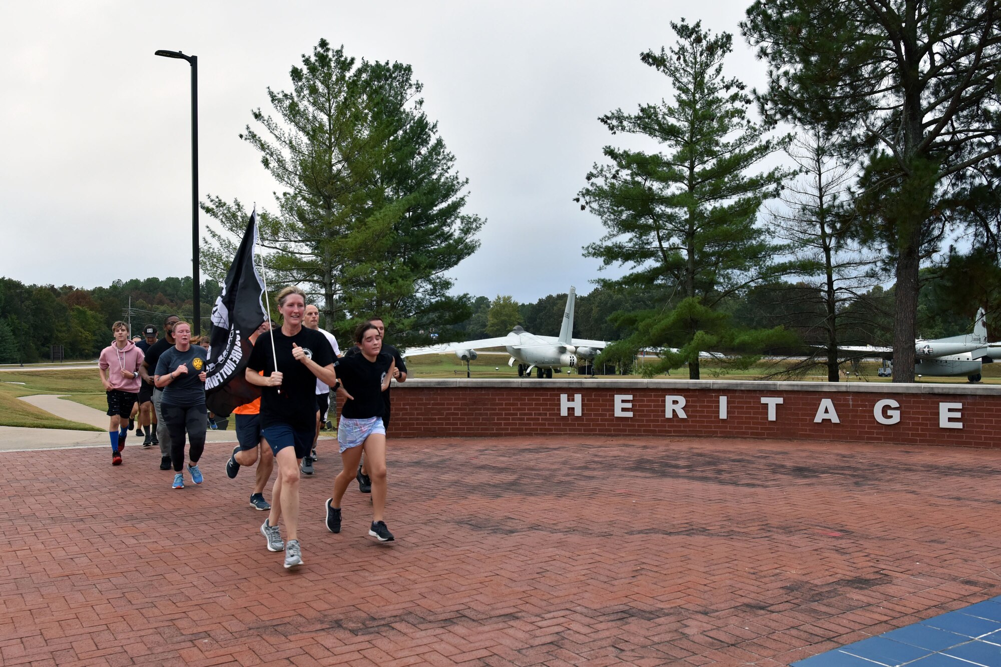 Airmen run with a flag